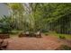 Brick patio with decorative brick wall and wrought-iron furniture in wooded backyard setting at 318 Tillamook Dr, Wake Forest, NC 27587