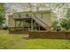Spacious lawn backyard features a wood deck and tiered brick walls with privacy landscaping at 318 Tillamook Dr, Wake Forest, NC 27587