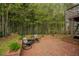Brick patio with decorative brick wall and wrought-iron furniture in wooded backyard setting at 318 Tillamook Dr, Wake Forest, NC 27587