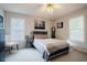 Bright bedroom features a comfortable bed, ceiling fan, and natural light from two windows at 318 Tillamook Dr, Wake Forest, NC 27587