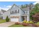 Charming two-story home featuring a brick-accented garage and a beautifully landscaped front yard at 320 Everly Mist Way, Wake Forest, NC 27587