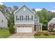 Charming two-story home featuring a brick-accented garage and a beautifully landscaped front yard at 320 Everly Mist Way, Wake Forest, NC 27587