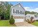 Two story home boasts blue siding, black shutters, manicured landscaping, and an attached garage at 320 Everly Mist Way, Wake Forest, NC 27587