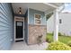 Inviting front porch with brick accents, an exterior light, and a view of the well-maintained lawn at 320 Everly Mist Way, Wake Forest, NC 27587