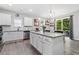 Open kitchen with granite counters, white cabinets, stainless steel appliances, and a view to the backyard at 320 Everly Mist Way, Wake Forest, NC 27587