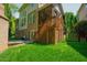 The lush backyard features a spacious patio with an outdoor fireplace and stairs to the upper screened deck at 3911 Morvan Way, Raleigh, NC 27612