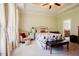 Bright bedroom with a floral pattern bedspread, tray ceiling with fan, and an upholstered chair by the window at 3911 Morvan Way, Raleigh, NC 27612
