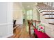 Grand entryway featuring hardwood floors, staircase with decorative iron railing, and natural light from large windows at 3911 Morvan Way, Raleigh, NC 27612