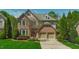 Traditional brick home featuring a two-car garage and well-manicured front lawn at 3911 Morvan Way, Raleigh, NC 27612