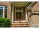 Close-up of brick home's front entrance, showcasing a solid wood door and classic design at 3911 Morvan Way, Raleigh, NC 27612