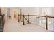 A carpeted hallway with wood and iron railings, leading to doorways and a chandelier-lit room at 3911 Morvan Way, Raleigh, NC 27612