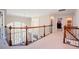 Hallway with wood railing overlooking the living room, with neutral walls and carpeted floors at 3911 Morvan Way, Raleigh, NC 27612