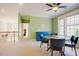 Living room featuring green walls, carpet flooring, a table, and bright natural lighting at 3911 Morvan Way, Raleigh, NC 27612