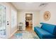 Bright sitting room with blue sofa, decorative rug, and doorway to an adjacent room at 3911 Morvan Way, Raleigh, NC 27612