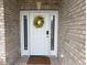 Close-up of the white front door with a yellow wreath and sidelights at 4001 Newby Rd, Rocky Mount, NC 27804