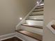 Well-lit staircase with a mix of hardwood and white painted elements at 4001 Newby Rd, Rocky Mount, NC 27804