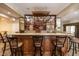 Basement bar featuring hardwood bar, granite countertops, custom shelving, and bar seating at 4038 Carpenter Pond Rd, Durham, NC 27703