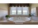 A soaking tub with a scenic view is the focal point in this relaxing bathroom at 4038 Carpenter Pond Rd, Durham, NC 27703