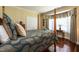 Bright bedroom with a four poster bed, wood floors, and large windows at 4038 Carpenter Pond Rd, Durham, NC 27703