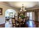 Formal dining room featuring hardwood floors, ornate chandelier, and seating for ten, next to the living room at 4038 Carpenter Pond Rd, Durham, NC 27703