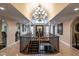 Elegant two-story foyer with marble floors, grand staircase, and stunning chandelier creating a luxurious entrance at 4038 Carpenter Pond Rd, Durham, NC 27703