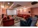 Home theater featuring a large screen, plush seating, and dimmable sconce lighting at 4038 Carpenter Pond Rd, Durham, NC 27703