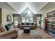 Bright living room with vaulted ceiling, large windows, fireplace, and comfortable seating on a decorative rug at 4038 Carpenter Pond Rd, Durham, NC 27703