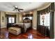 Luxurious main bedroom with bay windows, hardwood floors, a ceiling fan, and a seating area at 4038 Carpenter Pond Rd, Durham, NC 27703