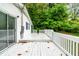 Wide shot of the back deck with white-painted wood surface and railing, leading to sliding glass door at 407 W Sixth St, Siler City, NC 27344