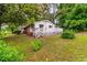 Charming home with a lush green lawn and mature trees, features a cozy front porch and back deck at 407 W Sixth St, Siler City, NC 27344