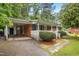 Well-maintained brick home featuring a carport and inviting front porch, complemented by lush landscaping at 407 W Sixth St, Siler City, NC 27344
