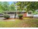Charming brick home with a welcoming porch, complemented by lush greenery and a well-maintained yard at 407 W Sixth St, Siler City, NC 27344