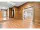 Open room with paneled walls and hardwood floors, connecting to another room through double french doors at 407 W Sixth St, Siler City, NC 27344