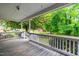 View from the porch with white railings and lush green trees at 407 W Sixth St, Siler City, NC 27344