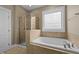 Bathroom featuring a soaking tub and tiled shower with glass door at 436 Edgepine Dr, Holly Springs, NC 27540