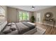 Bright bedroom with a large window, hardwood floors, and a glimpse into an en-suite bathroom at 436 Edgepine Dr, Holly Springs, NC 27540