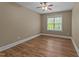 Comfortable bedroom with a ceiling fan and bright natural light streaming in through the window at 436 Edgepine Dr, Holly Springs, NC 27540