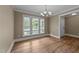 Bright dining room with large windows, classic chandelier, and easy access to other areas of the home at 436 Edgepine Dr, Holly Springs, NC 27540
