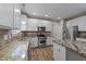 Modern kitchen boasts stainless steel appliances, granite countertops, and wood-look floors at 436 Edgepine Dr, Holly Springs, NC 27540