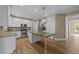 Modern kitchen features white cabinets, granite countertops, stainless steel appliances, and a central island at 436 Edgepine Dr, Holly Springs, NC 27540