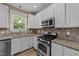 Well-equipped kitchen with stainless steel appliances, granite countertops, and ample lighting at 436 Edgepine Dr, Holly Springs, NC 27540