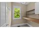 Functional laundry area with window view, built in desk and shelving at 436 Edgepine Dr, Holly Springs, NC 27540