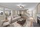 Inviting living room featuring a modern sofa, stylish rug, and an open layout to the kitchen and stairway at 436 Edgepine Dr, Holly Springs, NC 27540