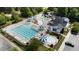 Aerial view of a community pool area with a large pool, water slides, splash pad and sundeck with ample seating and umbrellas at 436 Edgepine Dr, Holly Springs, NC 27540