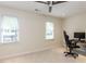 Bright bedroom featuring a ceiling fan, two windows, and a modern desk setup perfect for work or gaming at 4646 Fawnbrook Cir, Raleigh, NC 27612