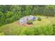 Aerial view of property displaying beautifully landscaped grounds, mature trees and expansive lawn at 4874 Thom Rd, Mebane, NC 27302