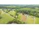 Drone shot of property lines showcasing wooded areas and pond at 4874 Thom Rd, Mebane, NC 27302