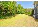 Expansive grassy backyard perfect for recreation or entertaining with mature trees and level ground at 4874 Thom Rd, Mebane, NC 27302
