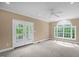 Spacious bedroom with French doors leading to the outside and arch-top window at 4874 Thom Rd, Mebane, NC 27302