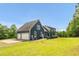 Side exterior featuring a two-car garage attached to the house surrounded by a green lawn at 4874 Thom Rd, Mebane, NC 27302